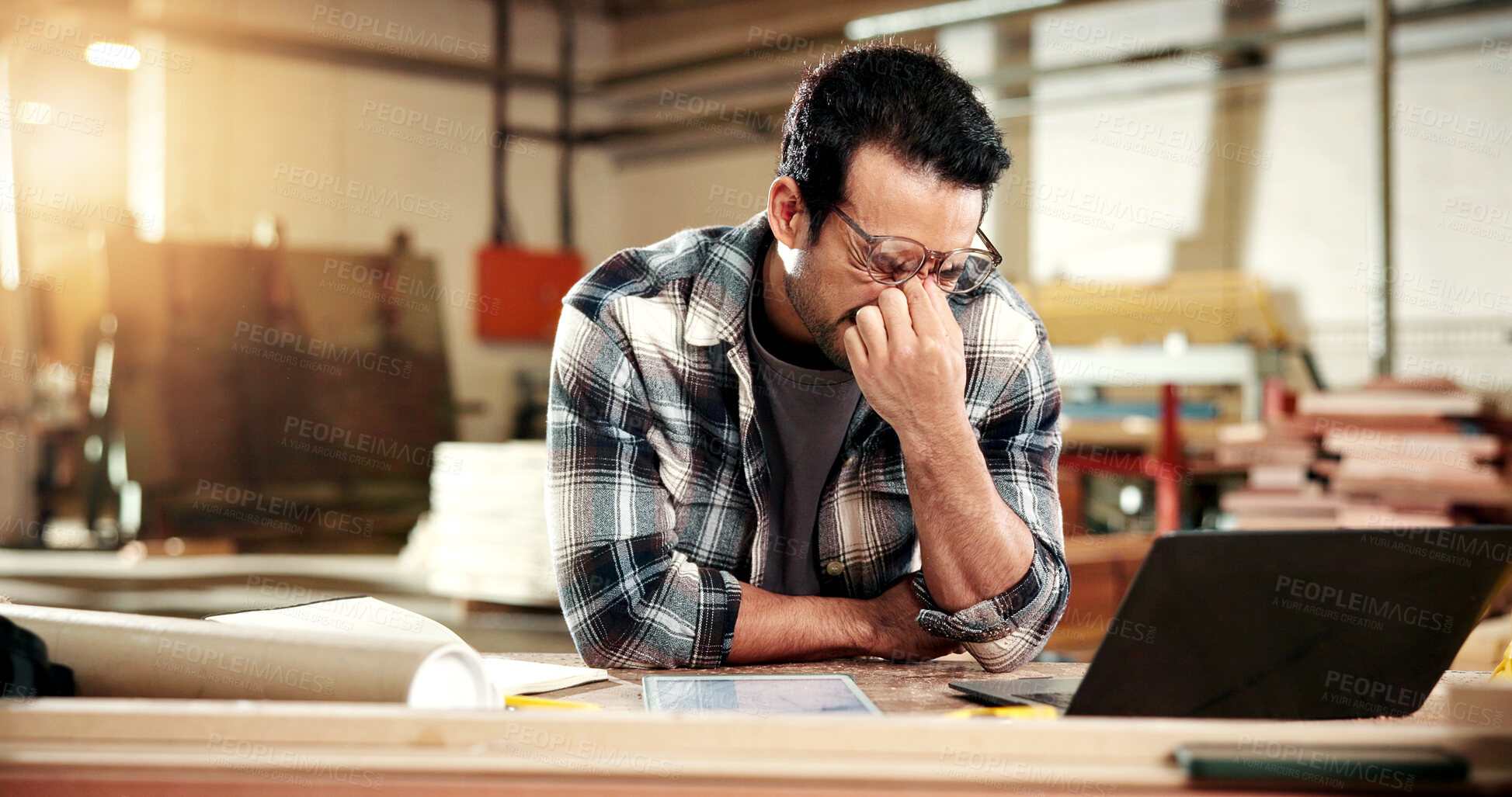 Buy stock photo Man, carpenter and glasses with eye strain in warehouse for wood production fail or freight delay. Frustrated, male person or carpentry mistake with stress or laptop for bad news on delivery schedule