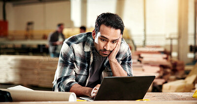 Buy stock photo Carpenter, stress and man with laptop in workshop, furniture production or delivery delay on website. Unhappy, woodworker and person with tech, reading and anxiety with financial pressure in factory