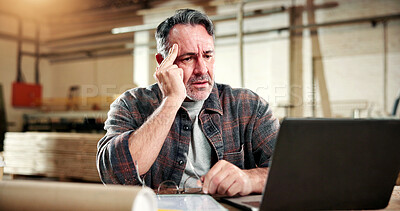 Buy stock photo Mature, man and carpenter with stress on laptop in warehouse for wood production delay or mistake. Male person, carpentry or headache with bad news on computer for timber inflation or lumber deadline