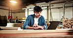 Carpenter, reading and man with laptop in workshop, online or searching for furniture design on web. Manufacturing, factory and person with technology, research and planning for woodworking project