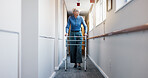Old woman, walk and physio at facility with walker, support and mobility aid for injury recovery. Thinking, corridor and senior person with disability, gait assistance and balance for physiotherapy