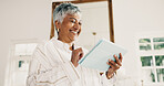 Mature, woman and smile in living room with tablet, browsing website and watch social media video. Happy, person and online entertainment in home with digital tech, internet connection and wellness.