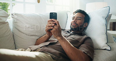 Buy stock photo Texting, relax or man on sofa with phone, online communication or social media scroll on day off. Digital, smile and person in house with tech, message notification and chatting on weekend break.