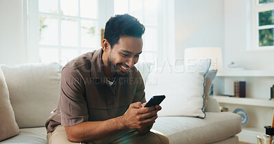 Buy stock photo Texting, smile and man on sofa with phone, online communication and social media scroll on day off. Digital, happy and person in home with tech, message notification and chatting on weekend break.