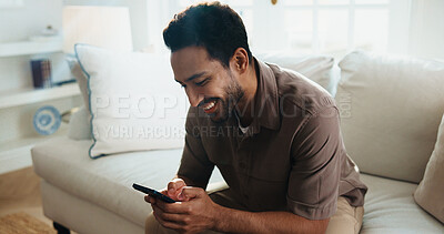 Buy stock photo Texting, happy and man on couch with phone, online communication and social media scroll on day off. Reading, smile and person in house with tech, message notification and chatting on weekend break.