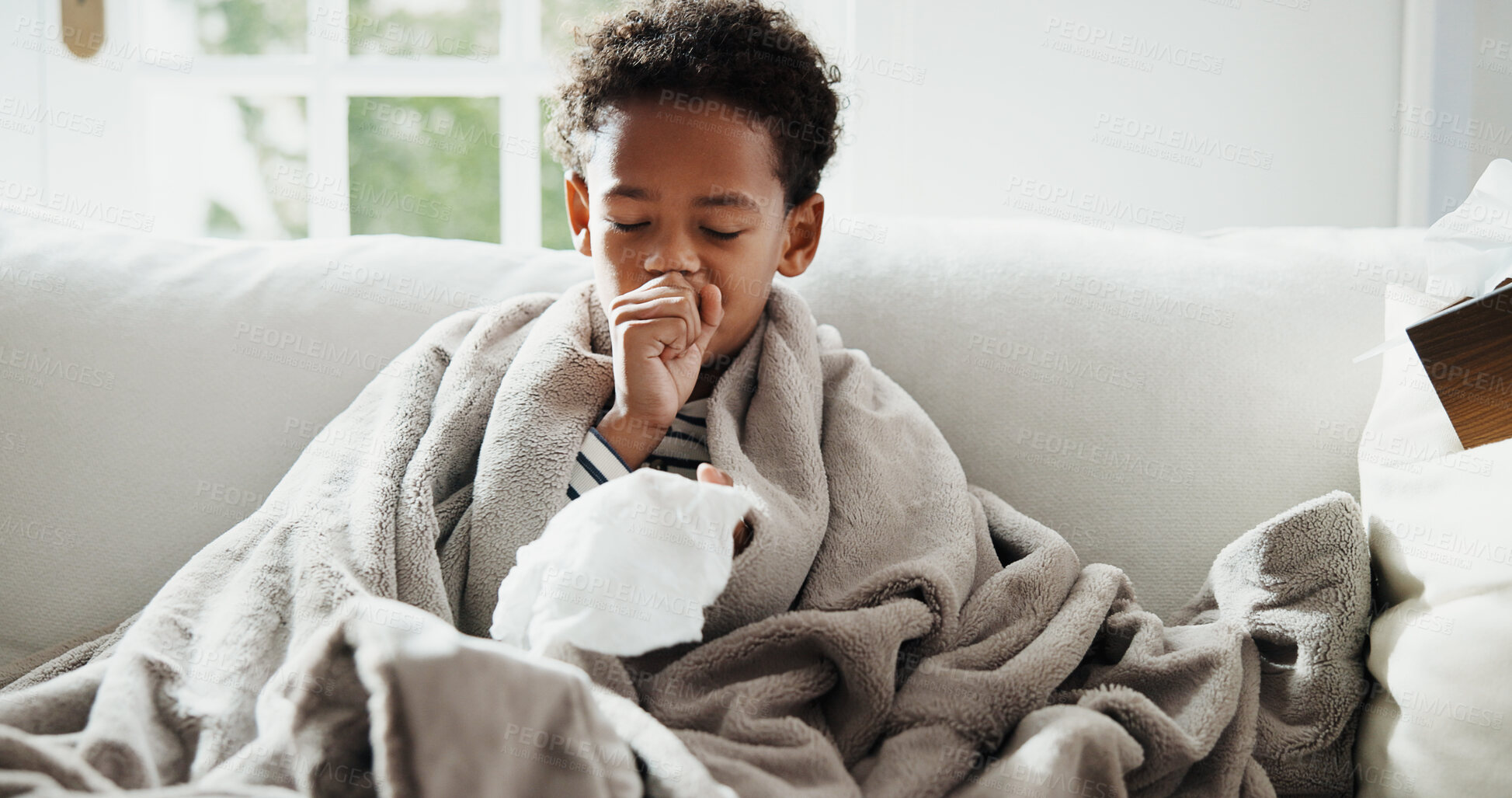 Buy stock photo Sick, cough and child on sofa with blanket for virus, sinus infection and blowing nose for flu. Home, health and boy with napkin, respiratory disease and cold for recovery, healing and rest on couch