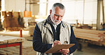 Carpenter, man and writing in workshop with clipboard, quality control inspection or woodwork review. Mature person, carpentry manager and notes for production checklist, manufacturing and planning.