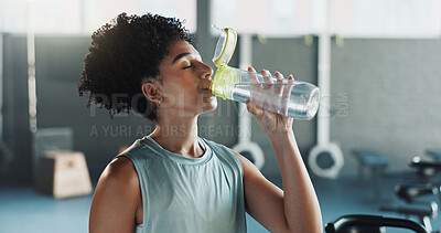 Buy stock photo Thirsty, woman and drink water in gym with break, healthy habits and vitality benefits for wellness. Active, person and exercise recovery in fitness club for hydration, electrolytes and nutrition.