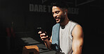 Man, break and phone in gym with earphones, browsing social media and smile for fitness app results. Happy, person and exercise recovery in health club with audio tech, website and listen to music.