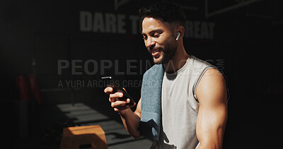 Buy stock photo Man, break and phone in gym with earphones, browsing social media and smile for fitness app results. Happy, person and exercise recovery in health club with audio tech, website and listen to music.