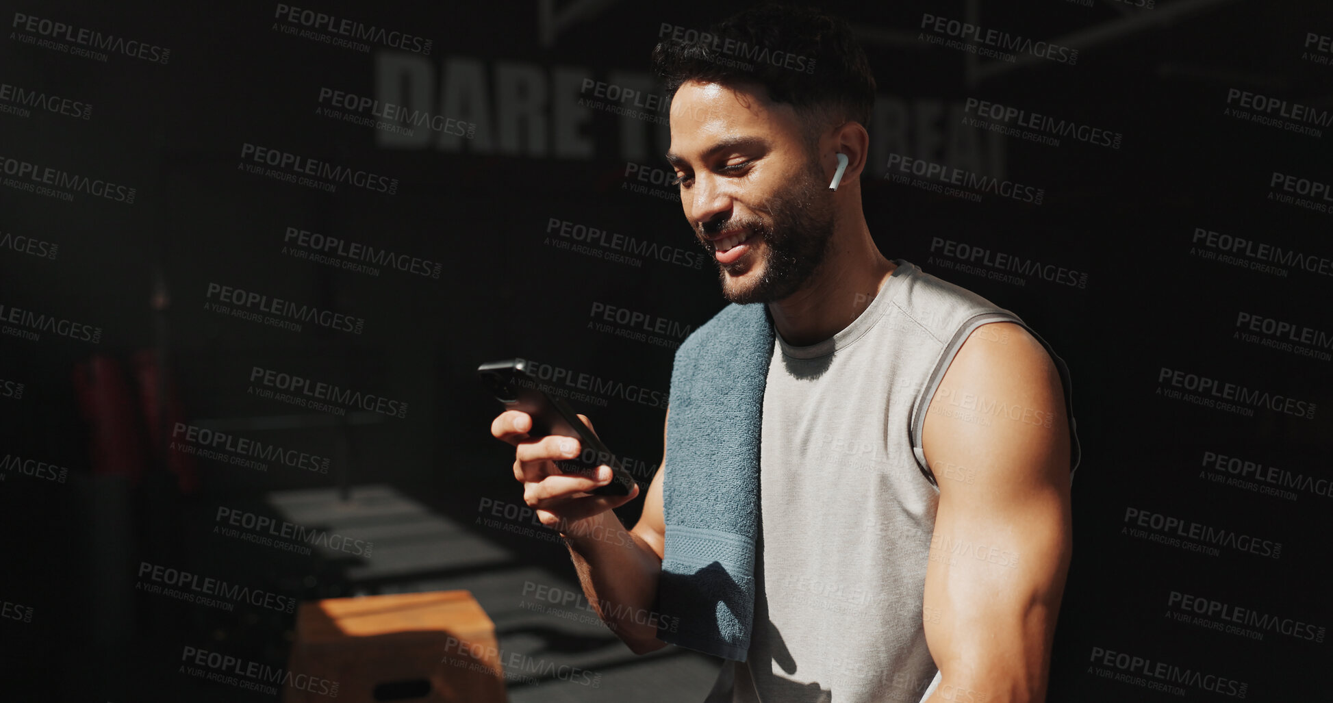 Buy stock photo Man, break and phone in gym with earphones, browsing social media and smile for fitness app results. Happy, person and exercise recovery in health club with audio tech, website and listen to music.