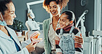 Dentist, girl and mother with jaw model for consultation, cleaning or gum disease for dental help. Happy, talk and kid with woman for teeth whitening, oral care or treatment plan for mouth procedure
