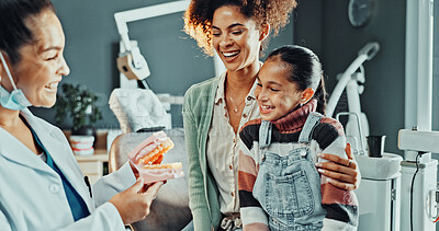 Buy stock photo Dentist, girl and mother with jaw model for consultation, cleaning or gum disease for dental help. Happy, talk and kid with mom for teeth whitening, oral care or treatment plan for mouth procedure