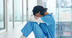 Woman, nurse and headache in grief, burnout or mistake on floor in hospital with healthcare anxiety. Mental health, sad physician and medical person with stress, loss or failed surgery at clinic