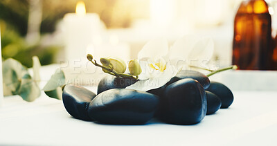 Buy stock photo Spa, empty and flower with hot stones at resort for aromatherapy, beauty treatment and wellness. Hospitality, background and heat therapy for stress relief, holistic healing and pamper for massage