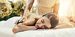 Spa, woman and hot stones for back massage, stress relief and holistic treatment for healing. Hospitality, resort and person with heat for pamper, self care and relax for zen, wellness and calm