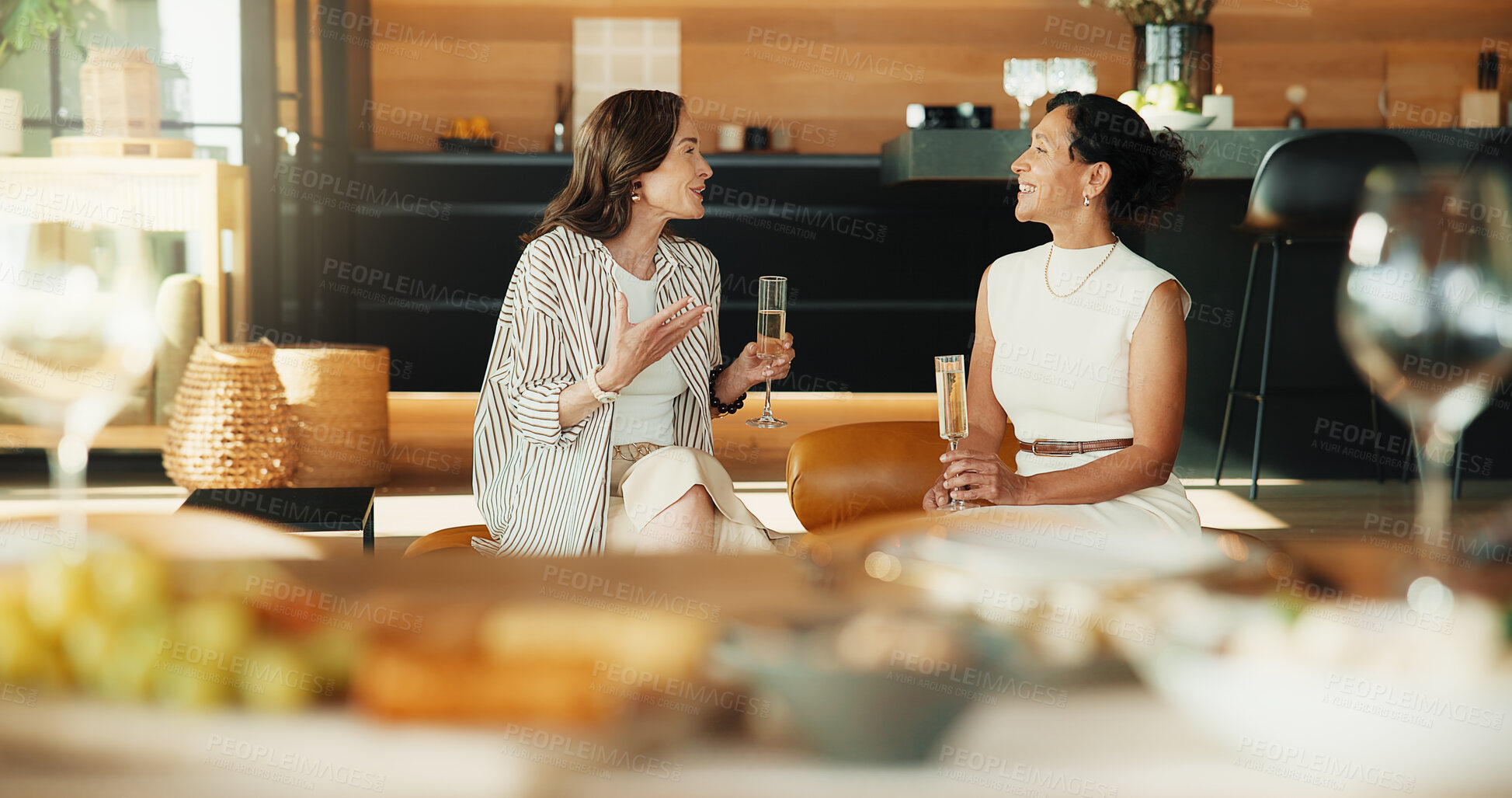 Buy stock photo Friends, relax and gossip in living room with champagne, conversation or bonding together on weekend. Happy, mature women and discussion in house with alcohol drink, connection and stress relief.