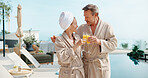 Drinks, couple and cheers at swimming pool on holiday, summer break and smile together at spa. Poolside, mature man and woman toast with mimosa, anniversary vacation and love celebration outdoor