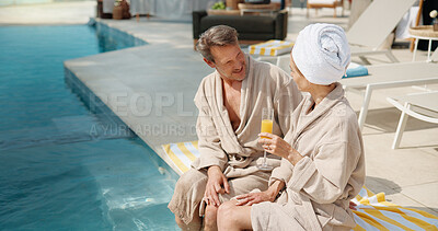 Buy stock photo Drinks, couple and talking at swimming pool on vacation, break and smile together on getaway. Poolside, mature man and woman with mimosa cocktail, holiday chat or outdoor at luxury resort with love