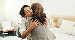 Visit, greeting and friends in home with hug, bonding together and excitement with reunion. Smile, mature woman and companion with loving embrace, friendly welcome and happy moment with connection.