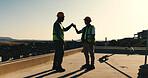 Fist bump, success and construction worker team on rooftop for completion, building or development. Sunset, people and celebrate outdoor for home renovation, engineering and deadline at property