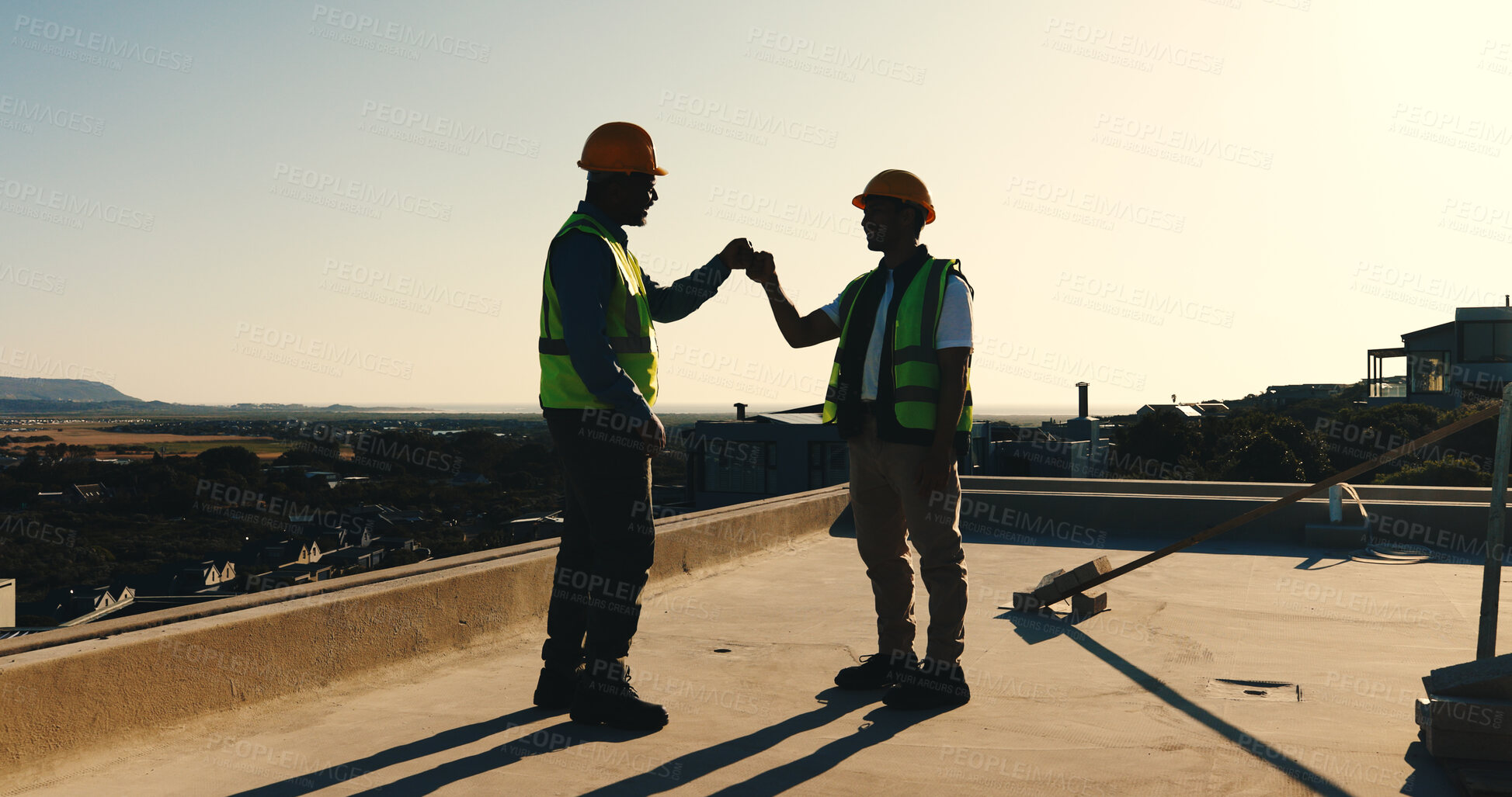 Buy stock photo Fist bump, success and construction worker team on rooftop for completion, building or development. Sunset, people and celebrate outdoor for home renovation, engineering and deadline at property