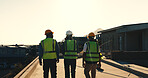 Engineer, walk and meeting on site with construction worker, property evaluation or project feedback. Back, people and supervisor outdoor on rooftop with builder, infrastructure assessment and plan.