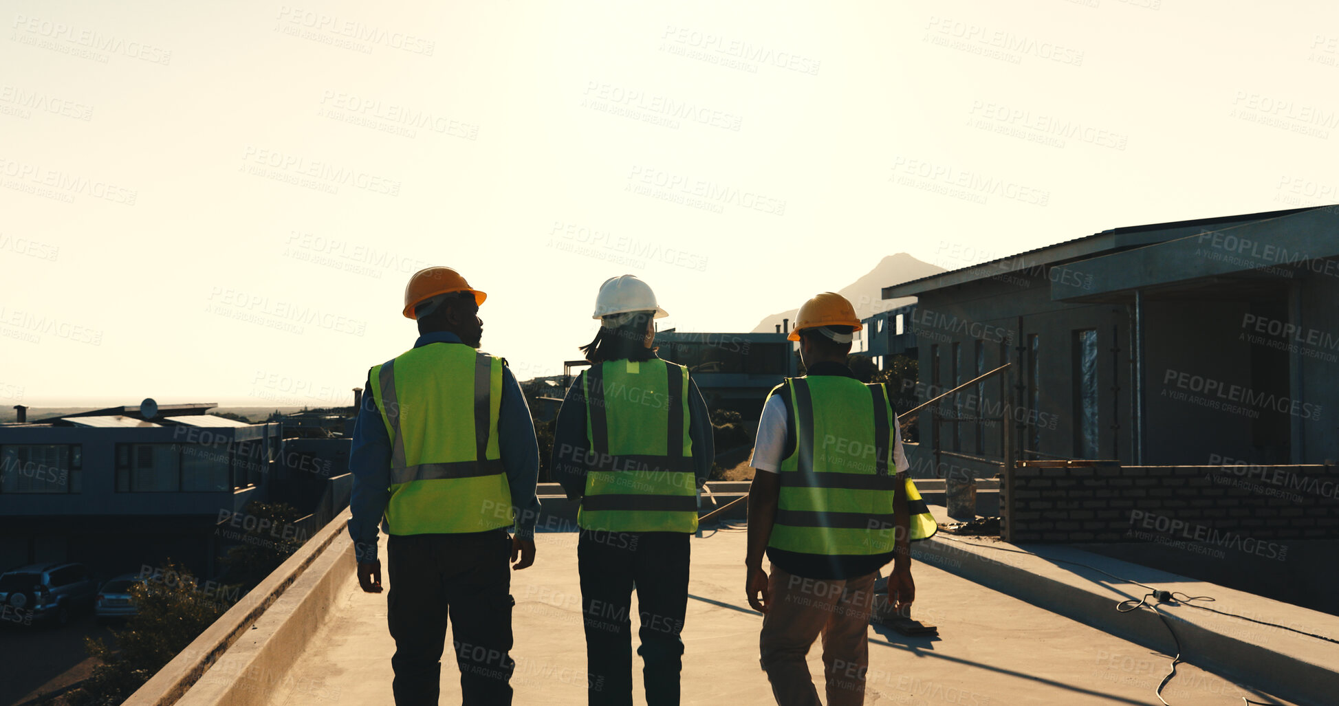 Buy stock photo Engineer, walk and meeting on site with construction worker, property evaluation or project feedback. Back, people and supervisor outdoor on rooftop with builder, infrastructure assessment and plan.