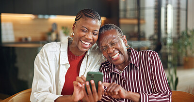 Buy stock photo Senior mother, laugh and woman with phone in house, entertainment and watching video with daughter. Family, online and bonding with elderly parent, happy and black people with mobile for funny film