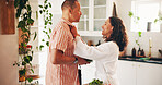 Happy, couple and shirt with help in kitchen for morning preparation, love or support in home. Man, woman and getting ready with smile or care for assistance, meal prep or leaving for work in house