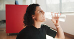 Woman, fitness and drinking water in gym for wellness, rehydration or body detox or refreshing. Girl, thirsty or bottle in studio for electrolytes, mineral beverage or healthy lifestyle for self care