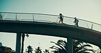 People, running and bridge for fitness, workout and wellness in low angle, urban town and exercise. Couple, runner or athlete training for resilience, outdoor and morning for health, cardio and sport