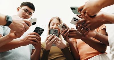 Buy stock photo Hands, friends and phone for connection outdoor, share contact or networking on social media. Group, people or low angle with mobile for communication together, download community app or text message