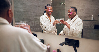 Buy stock photo Toast, skincare and woman with senior mom for wellness, eye mask and pamper for bonding and love. Family, drinks and African daughter, mother and mirror for hygiene, self care and beauty in home