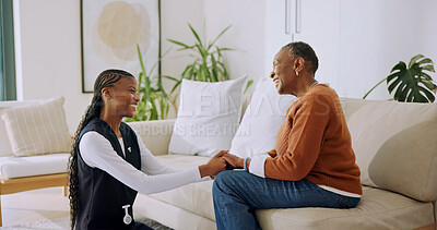 Buy stock photo Happy, old woman and holding hands with nurse in nursing home, assisted living or gratitude for help. Health, caregiver and smile with senior black person, support and laugh with patient in lounge