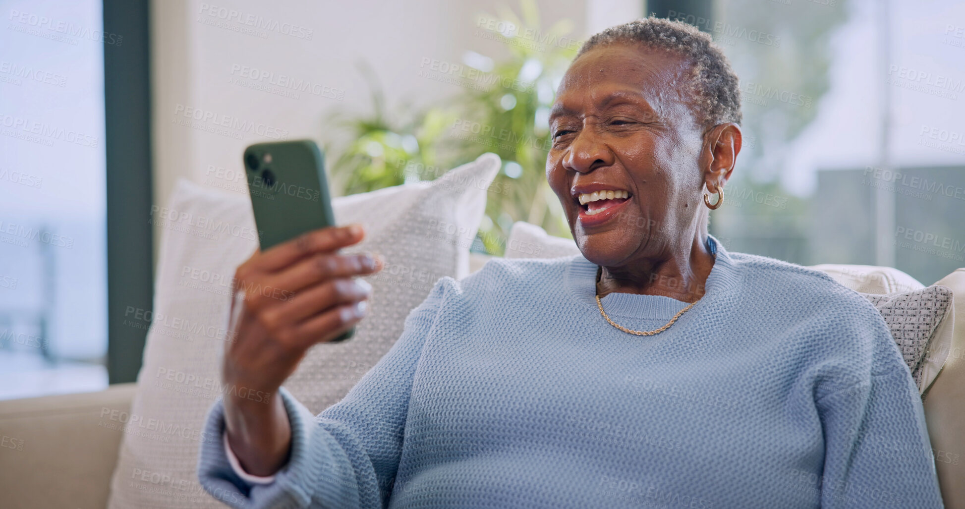 Buy stock photo Video call, online and old woman with phone in lounge, laugh and communication with contact on web. Retirement, home and senior black person with mobile, happiness and virtual chat with social media