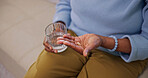 Hands, pill and old woman in home with water, supplements and prescription drugs for chronic illness. Senior person, medicine and glass with liquid, vitamins and antibiotics for health condition.