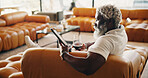Tablet, online and man with wine in lounge, relax and reading ebook with app subscription in house. Fiction, entertainment and mature black person with alcohol, chilling and reader with tech in home