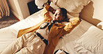 Bed, woman and unwind in hotel room with peace, travel exhaustion and thinking of vacation itinerary. Above, tourist and person relax in accommodation with fatigue, planning and vision for holiday.