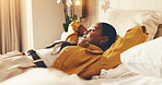 Bed, woman and relax in hotel room with thinking, travel exhaustion and vision of vacation itinerary. Calm, tourist and person rest in accommodation with fatigue, daydream and unwind for holiday.