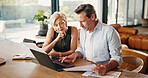 Documents, finance and mature couple on laptop for mortgage, online banking and bills in home. Talking, marriage and man with woman with computer, financial report and paperwork for savings or budget