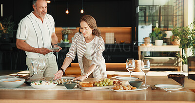 Buy stock photo Couple, help and food on dining table at house for social gathering, meal and place setting. Mature man, happy woman and together in home with healthy snack, hosting and dietary for party catering