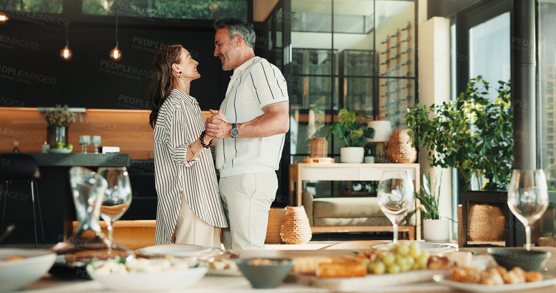 Buy stock photo Love, dance and mature couple in home for anniversary celebration, holding hands and smile together. Happy man, woman and moving to music for marriage connection, partner support and care at lunch