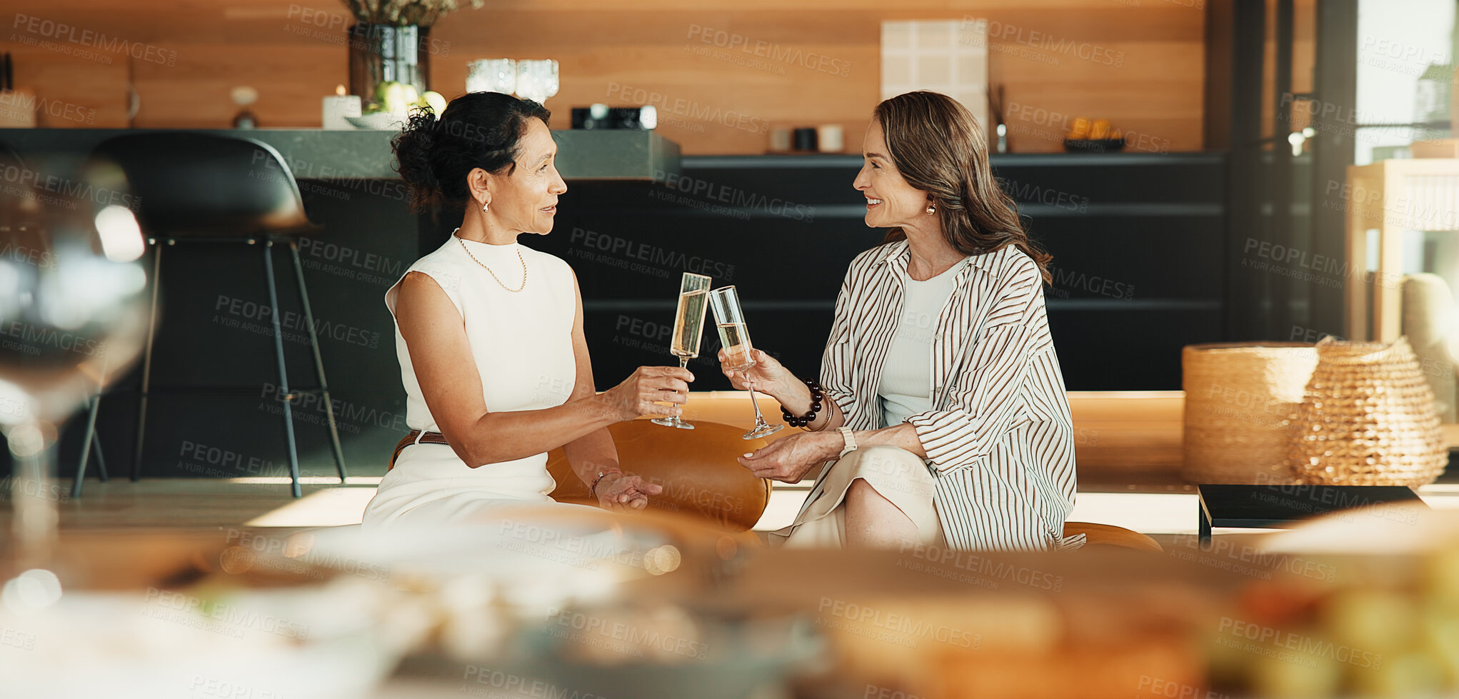 Buy stock photo Friends, relax and toast in home with champagne, bonding together or congratulations for achievement. Happy, mature women and cheers on sofa with alcohol drink, conversation or celebration of success