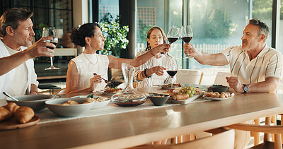 Buy stock photo Friends, wine and food or cheers in house for celebration, social gathering or reunion dinner. Mature men, women and happy with alcohol drinks in home for toast, healthy meal and holiday with couples