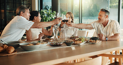 Buy stock photo Friends, red wine and food or cheers in house for celebration, social gathering or dinner. Mature men, women and happy with alcohol drinks in home for toast, healthy meal and holiday with couples