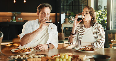 Buy stock photo Couple, food and drinking in home with wine, relationship milestone and anniversary meal at table. Woman, mature man and relax with alcohol, marriage bonding and lunch date with connection in house