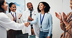 Doctor, people and meeting with handshake for winning, team success or promotion in hospital. Happy, woman and shaking hands with healthcare workers or applause for congratulations in clinic seminar