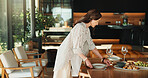 Woman, table and preparation in home for dining feast, social gathering event or hospitality. Mature, female person or setting dinner with plate, food or crockery for eating service or accommodation