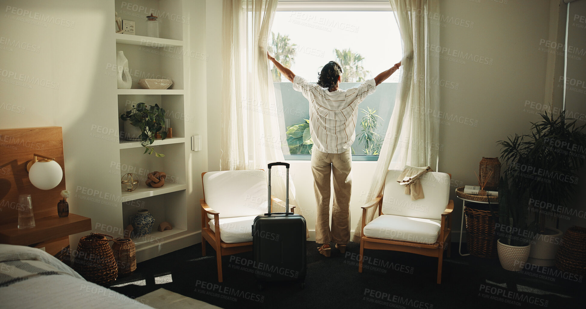 Buy stock photo Window, curtain and woman with travel suitcase in hotel for holiday getaway or vacation trip. Back of person, relax and awake with sunshine for weekend or morning stay in luxury bedroom or resort